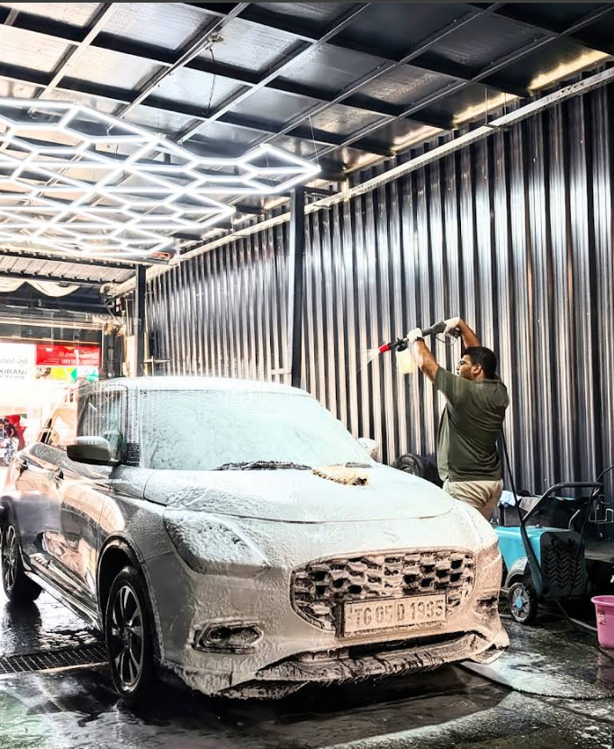 Technician applying thick foam wash to a vehicle inside the Magic Car Spa detailing bay